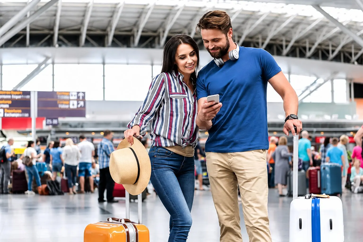 Casal no aeroporto com malas olhando o celular juntos